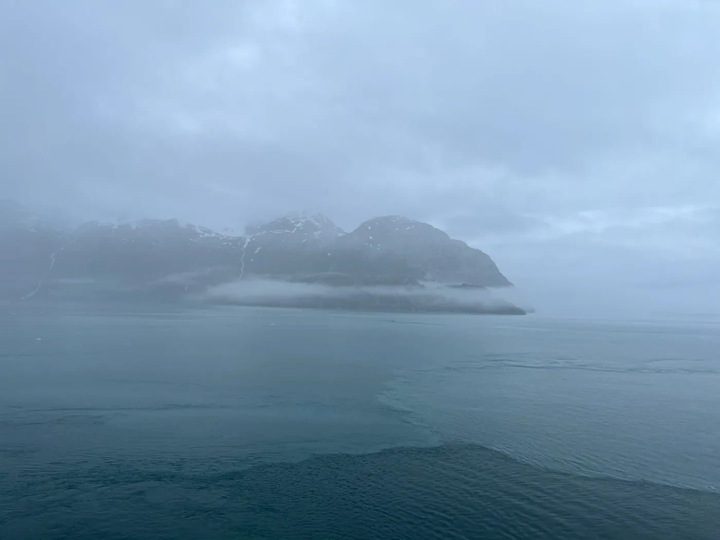 Misty mountains rising over the water in Glacier Bay National Park on an Alaska cruise