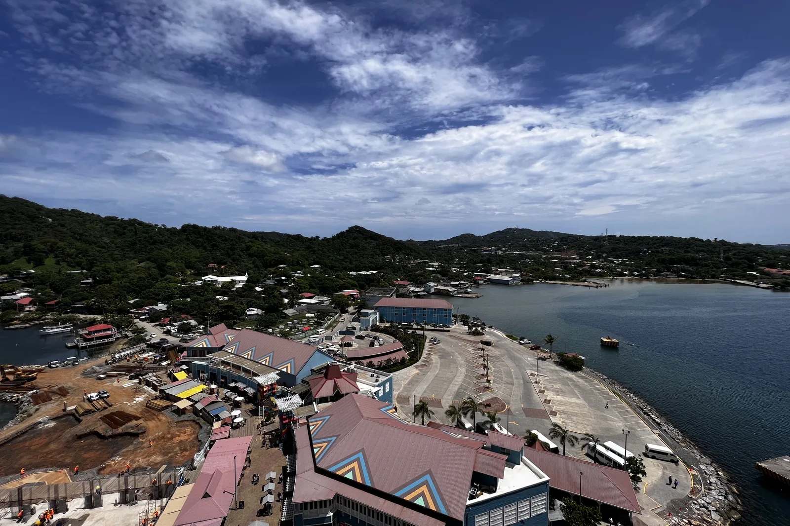 A Caribbean port town seen from the deck of a cruise ship, with the harbor and hills behind it