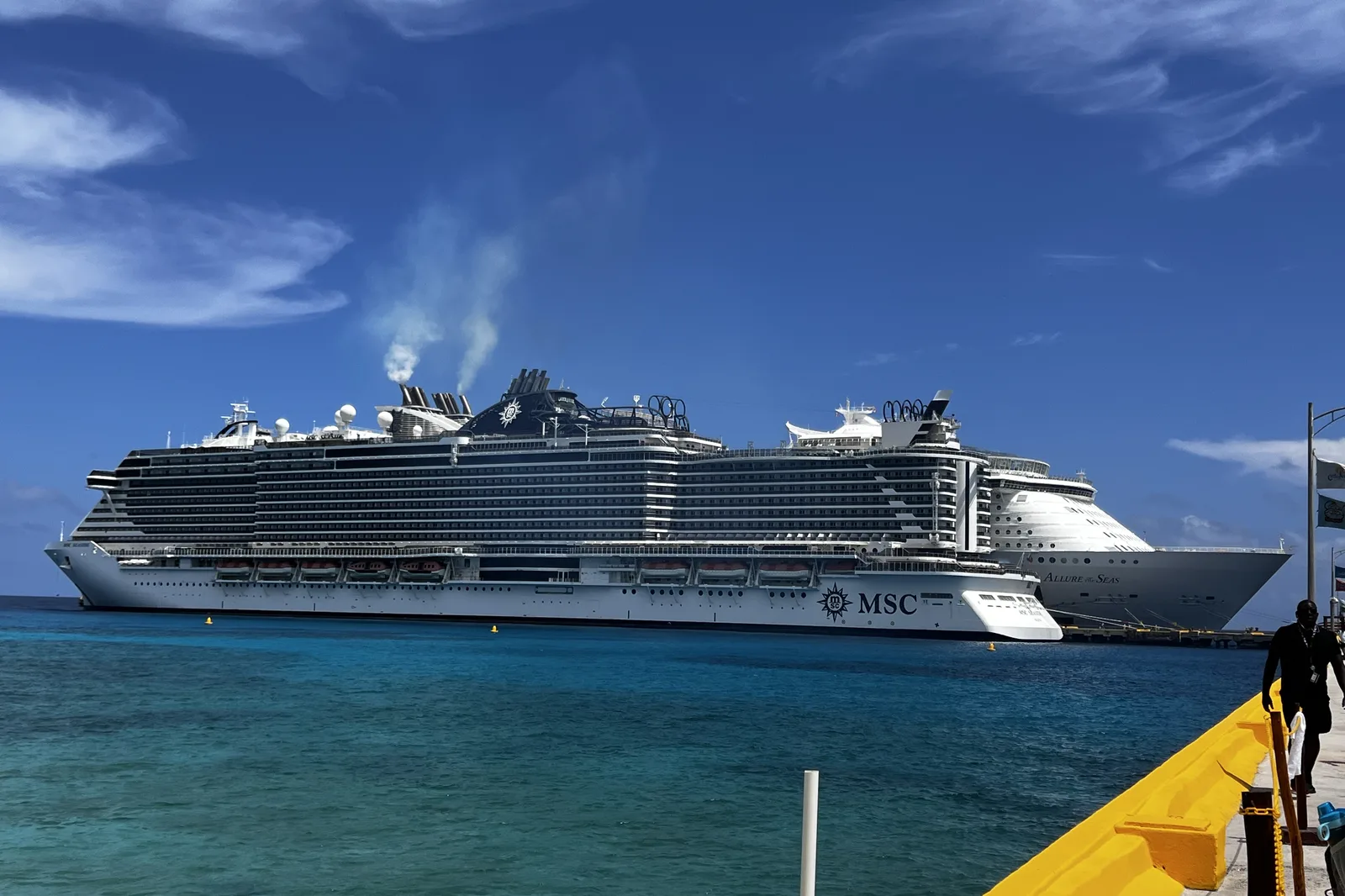 A large ocean cruise ship alongside the pier, seen from the dock