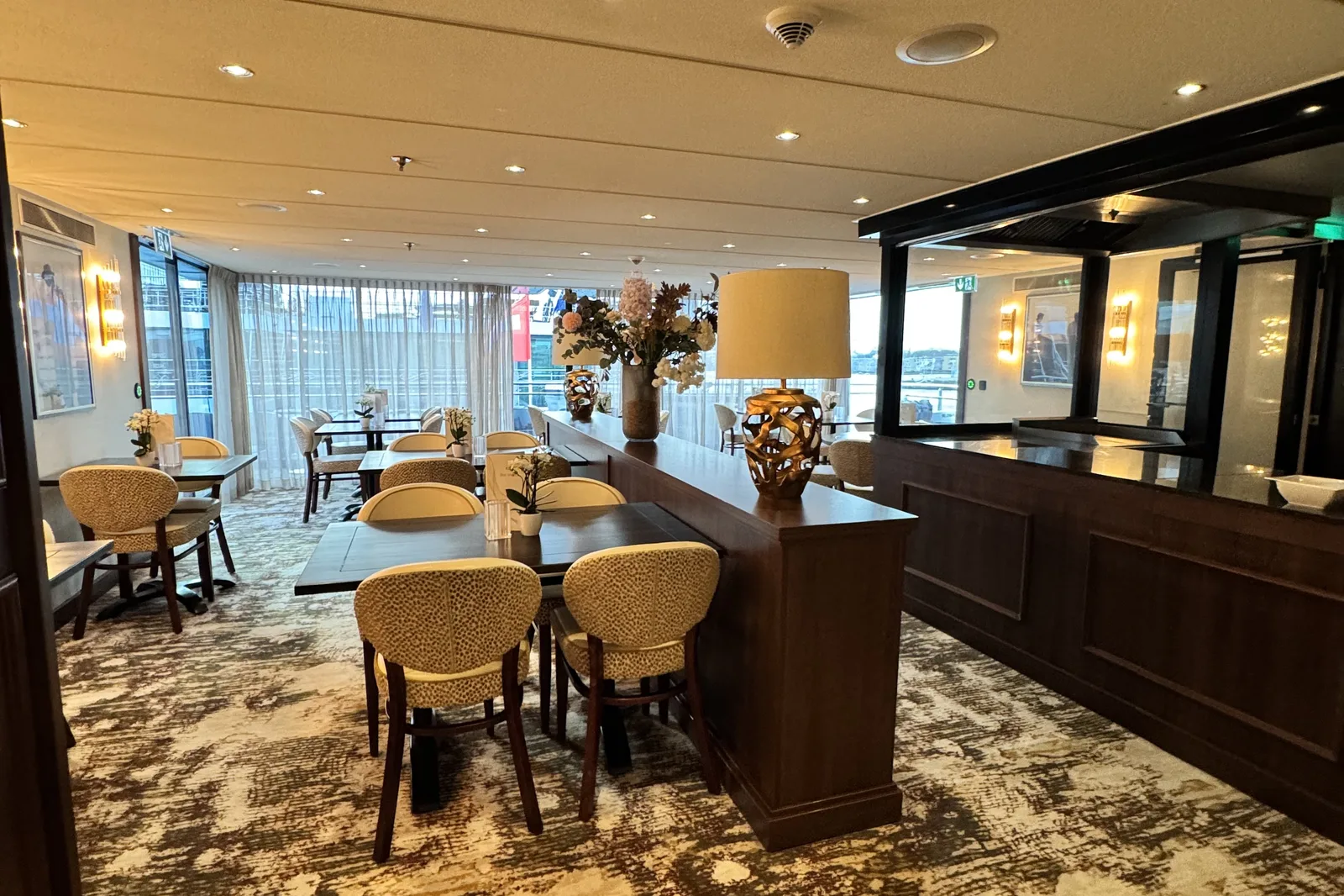 The dining room of a river ship laid out with tables of several different sizes