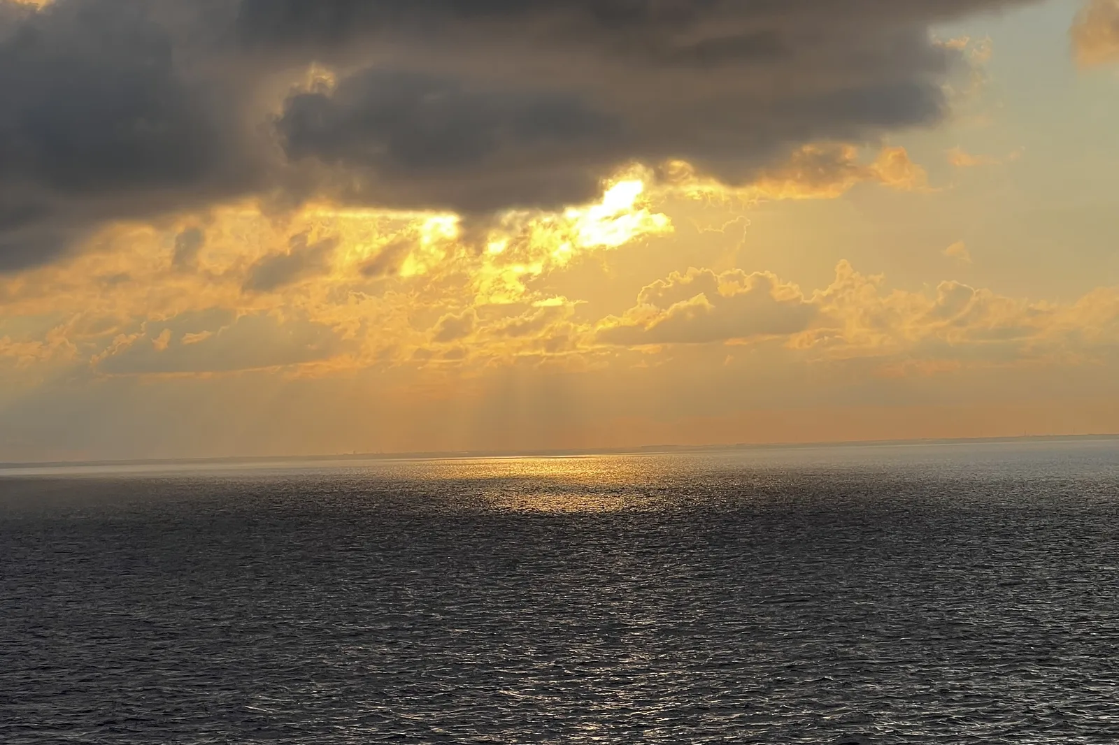 Sunset over the open ocean seen from the deck of a cruise ship