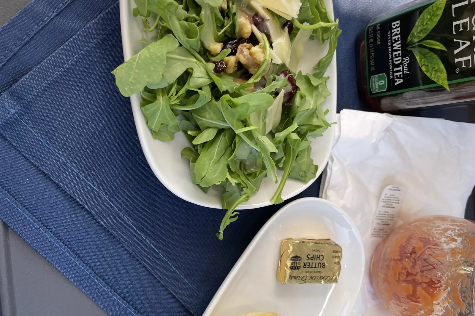A fresh salad and iced tea served on the tray table aboard Rocky Mountaineer's Canyon Spirit