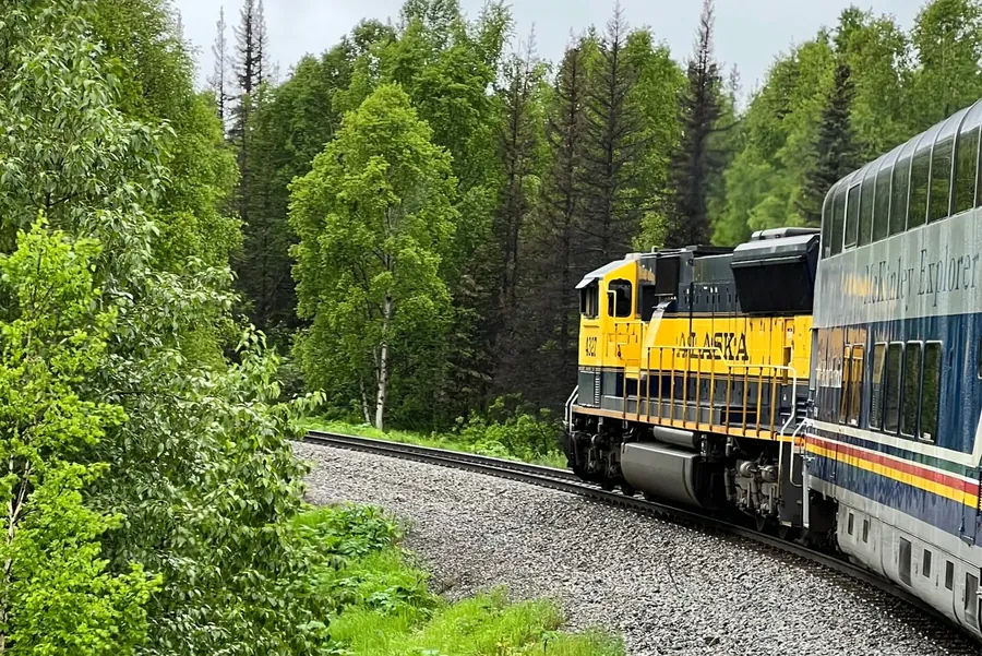 A train winding through green mountain scenery, the kind of multi-country European rail journey I plan